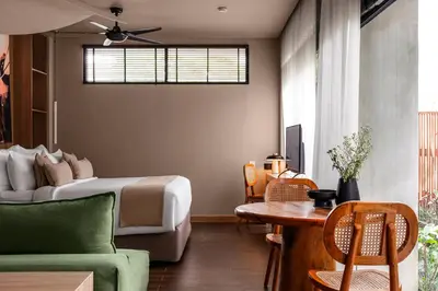 a bedroom with a bed and a couch and a table at Aviator Bali in Canggu