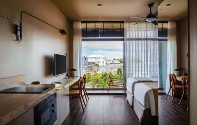 a kitchen with a bed and a large window at Aviator Bali in Canggu