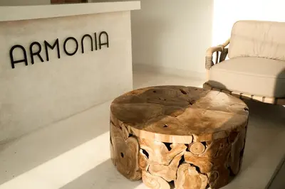 a wooden stump coffee table in front of a chair at Armonia Bali Legian Villas in Legian