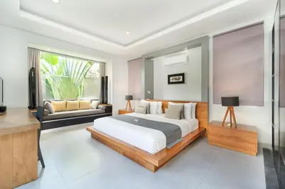 a bedroom with a large bed and a couch at The Black Pearl - The Best 1br Villa In Seminyak in Seminyak