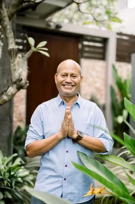 a man is smiling while clasping his hands at The Black Pearl - The Best 1br Villa In Seminyak in Seminyak