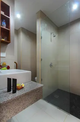 a bathroom with a shower and a tub and a sink at Kubu Cempaka Seminyak in Seminyak