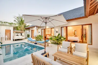 an outdoor patio with a pool and a villa at Villa Mayo in Legian