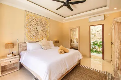 a bedroom with a bed and a ceiling fan at Villa Mayo in Legian