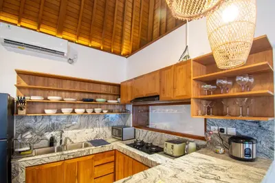 a kitchen with wooden cabinets and a counter top at Villa Mayo in Legian