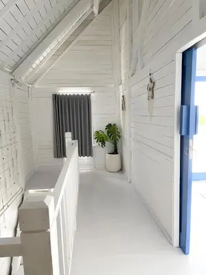 a white porch with a potted plant and a window at Kenzo hut3 mesari in Seminyak