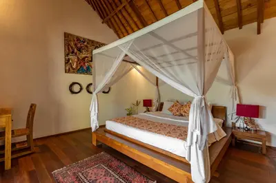 a bedroom with a large bed with a canopy at Villa Tago - 5 BR Villa in Umalas in Kerobokan