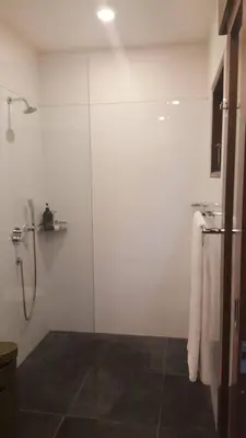 a bathroom with a shower with a glass door at ViLLA GREEN MANGO SEMINYAK BALI in Seminyak