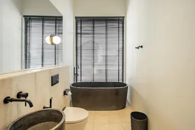 a bathroom with a large tub and a toilet at The Fernweh Umalas in Canggu