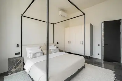 a bedroom with a large bed with a glass canopy at The Fernweh Umalas in Canggu