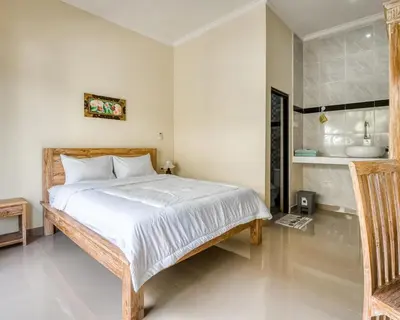 a bedroom with a large bed and a sink at Dhita Kubu in Kerobokan