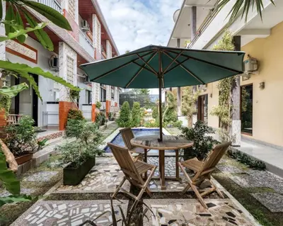 a table and chairs with an umbrella on a patio at Dhita Kubu in Kerobokan