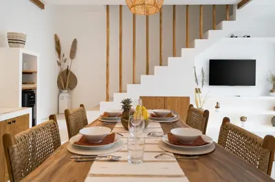 a dining room with a wooden table and chairs at Villa Casa Gaia 1 by BaliSuperHost in Umalas