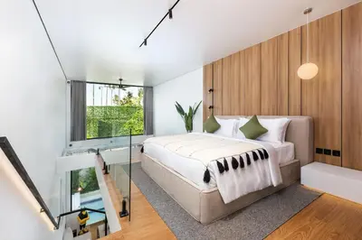 a bedroom with a bed and a glass wall at Alex Villas Complex N5 in Canggu