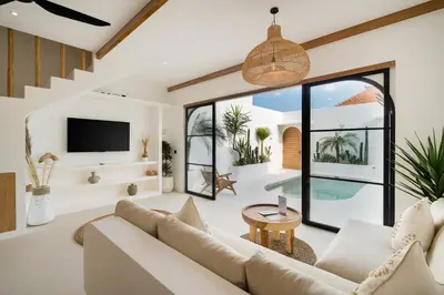 a living room with a white couch and a tv at Villa Casa Gaia 5 by BaliSuperHost in Kerobokan