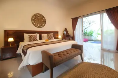 a bedroom with a large bed and a sliding glass door at Bougainvillea Villa Seminyak by Parigata in Seminyak