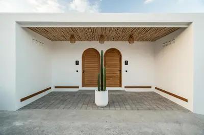 a room with two wooden doors and a cactus at Villa Casa Gaia 6 by BaliSuperHost in Kerobokan