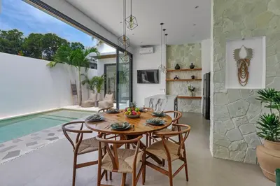 a dining room with a table and chairs and a swimming pool at New Magnificent 3BR 5min to Finns & Berawa Beach Villa Alemar in Canggu