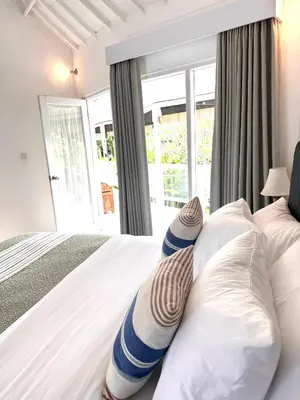 a bedroom with a bed with pillows and a window at Greenhouse Villa in Kerobokan