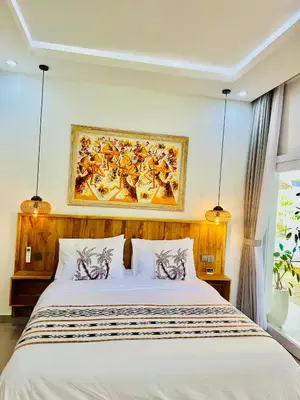 a bedroom with a bed with a painting on the wall at Tirta Mumbul Villa in Badung