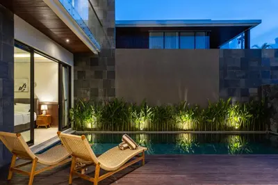 a house with a swimming pool and two chairs at Luxury Chic 3bd Modern Villa in Umalas in Kerobokan