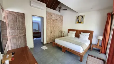 a bedroom with a bed and a desk in a room at The Decks Bali in Legian