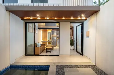 a house with a glass door leading into a living room at The New Moon Umalas in Seminyak