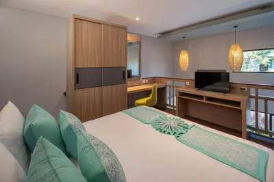 a hotel room with a bed and a television at The New Moon Umalas in Seminyak