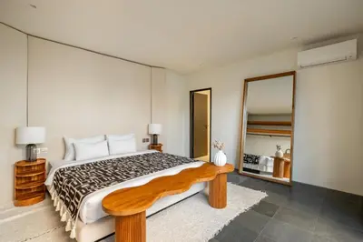 a bedroom with a large bed and a large mirror at Casa Siella in Canggu