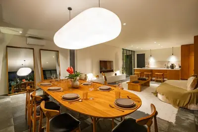 a living room with a large wooden table with chairs at Casa Siella in Canggu