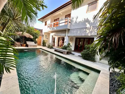 a swimming pool in front of a house at The Getaway Villa Seminyak Bali in Seminyak