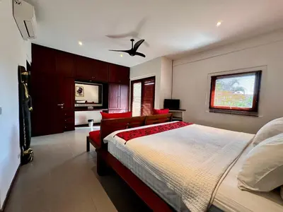 a bedroom with a large bed with red accents at The Getaway Villa Seminyak Bali in Seminyak