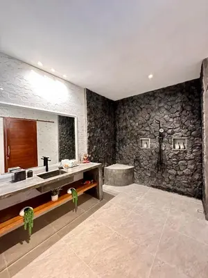 a bathroom with a sink and a stone wall at The Getaway Villa Seminyak Bali in Seminyak