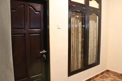 a wooden door and a mirror in a room at Chillin Kuta Homestay in Kuta