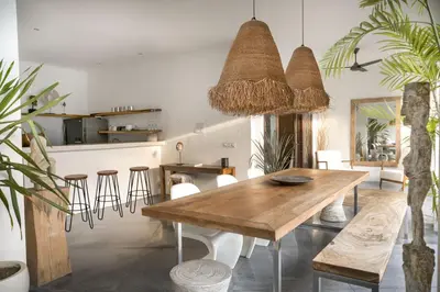 a dining room with a wooden table and chairs at Tropical 3bdr poolvilla in heart of Seminyak in Seminyak
