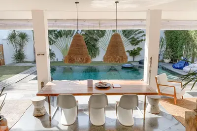 a dining room with a table and chairs and a pool at Tropical 3bdr poolvilla in heart of Seminyak in Seminyak