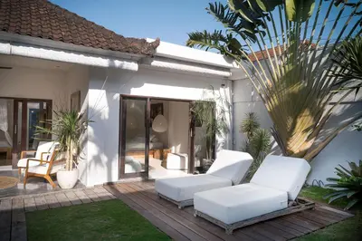 a patio with two white couches on a deck at Tropical 3bdr poolvilla in heart of Seminyak in Seminyak