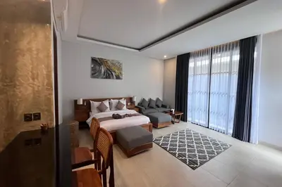 a bedroom with a bed and a couch and a window at Ranala Coliving in Seminyak