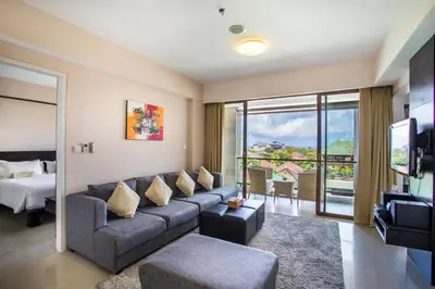 a living room with a couch and a bed at Kuta Reef Apartments in Kuta