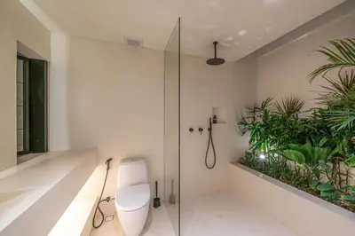 a bathroom with a toilet and a glass shower at Casa Vera - Delightful 1-Bedroom Villas in the Heart of Umalas in Canggu