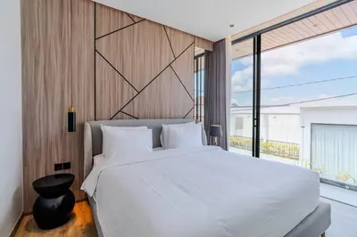 a bedroom with a large white bed and a large window at Casa Estella Stunning 2BR in Umalas Canggu in Kerobokan