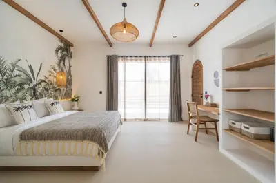a bedroom with a bed and a desk and a window at Villa Casa Gaia 2 by BaliSuperHost in Kerobokan