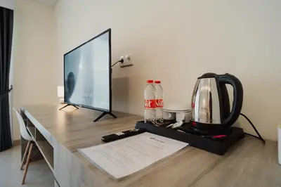 a desk with a computer monitor and a coffee maker at D'Leafy Seminyak in Seminyak