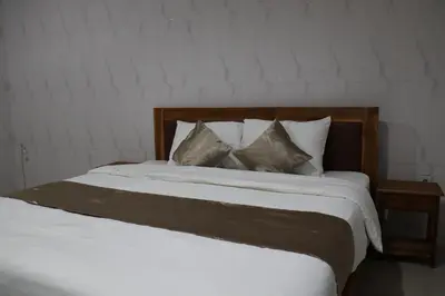 a large bed with white sheets and pillows at Kubu Celagi Manis in Jimbaran