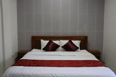 a bedroom with a large bed with two pillows at Kubu Celagi Manis in Jimbaran