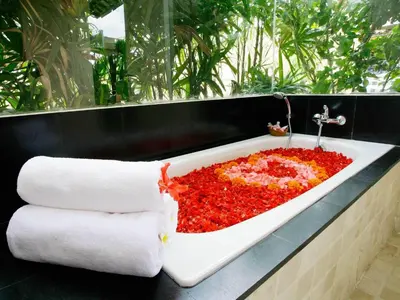 a bathtub filled with red flowers on a counter at Villa Cokelat in Canggu
