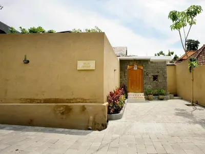 a building with a door and a courtyard with plants at Villa Cokelat in Canggu