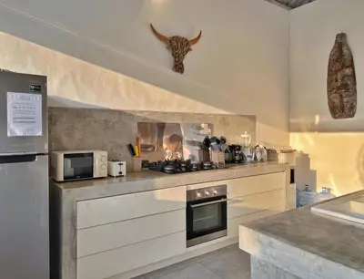 a kitchen with a counter with a microwave and a stove at Villa Rocher - Modern 3 BR Villa Batu Belig 3 min beach in Seminyak