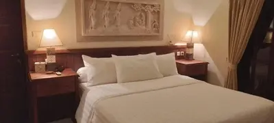 a bedroom with a white bed with two night stands at Villa Gadja Bali in Jimbaran