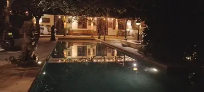 a house with a swimming pool at night at Villa Gadja Bali in Jimbaran